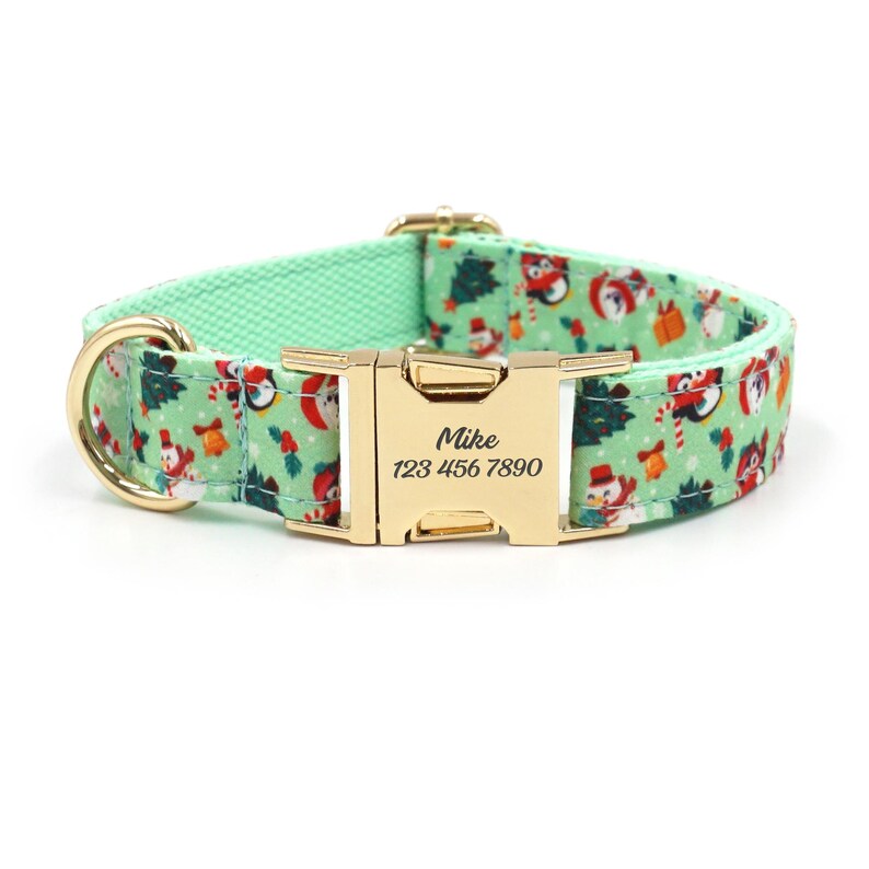 May include: A green dog collar with a gold buckle and a personalized name tag that reads "Mike 123 456 7890". The collar features a festive Christmas pattern with snowmen, candy canes, and holly.