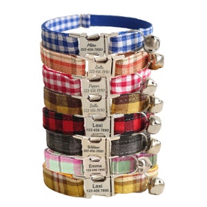 May include: A stack of eight colorful cat collars with personalized name tags and bells. The collars feature various plaid and gingham patterns in red, blue, green, yellow, and black.