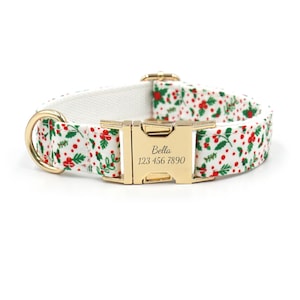 May include: White dog collar with a red and green holly pattern and gold hardware. The collar is personalized with the name "Bella" and the phone number "123 456 7890".