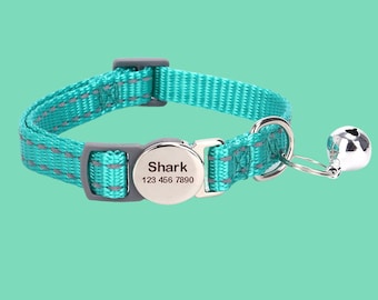 May include: Teal blue cat collar with a silver bell and a silver tag that reads "Shark 123 456 7890".