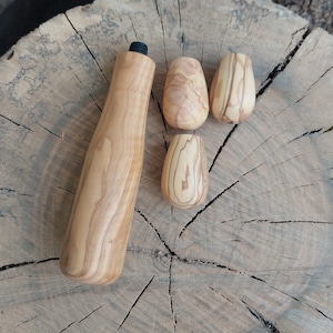 Puede incluir: Cuatro herramientas de madera para tejer, incluyendo una herramienta de mango largo y tres herramientas más pequeñas. Las herramientas están hechas de madera marrón claro con un patrón de veta natural.