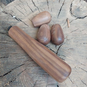 以下が含まれることがあります： クルミ材で作られた木製のノブが4つ。3つは丸型、1つは細長く円筒形です。