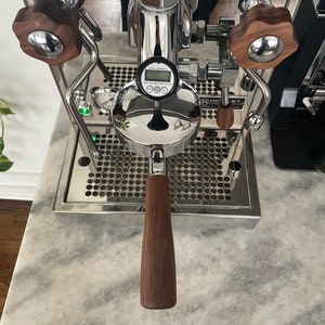 Könnte beinhalten: Eine Espressomaschine aus Edelstahl mit Chromoberfläche und einem Holzgriff. Die Maschine hat ein digitales Display, das "TEMP 158.0F 1.0 BAR" anzeigt.