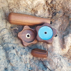 Puede incluir: Un conjunto de tres pomos de madera con una etiqueta azul y blanca que dice "Pro-Tec - Hecho a mano - Desde 1985".