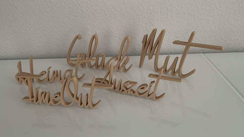 May include: Five wooden signs with different words written on them. The words are "Heimat", "Time Out", "Gl&uuml;ck", "Mut", and "Auszeit".