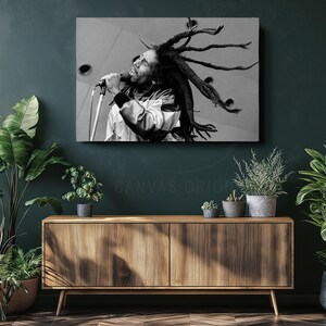a black and white photo of a man with dreadlocks