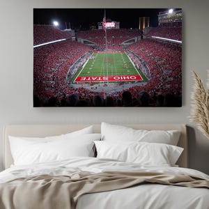 a bed in a room with a large picture on the wall