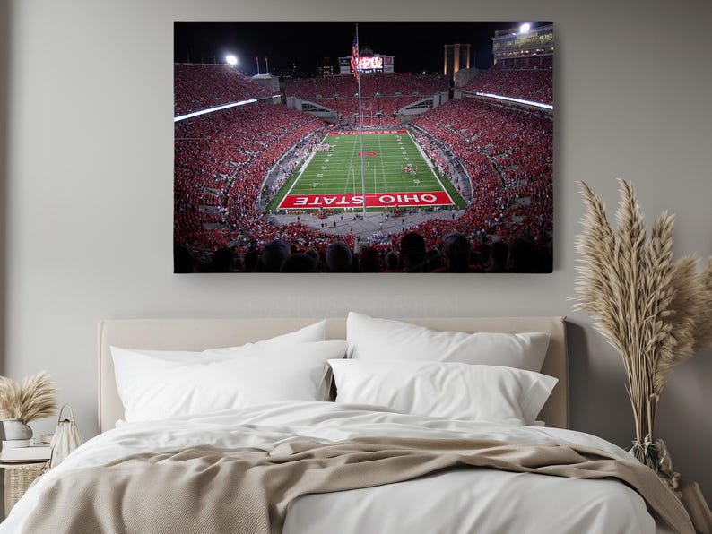 a bed in a room with a large picture on the wall
