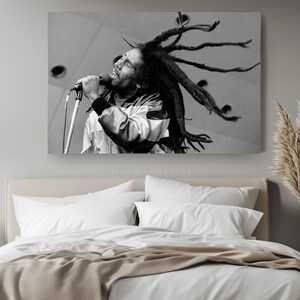 a bed with a white comforter and a picture of a man with dreadlock