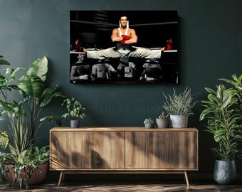 May include: A rectangular wall canvas print featuring a person in a white tank top and white pants performing a full split on boxing ring ropes. The person wears red boxing gloves and is positioned above several other figures in a dark setting.