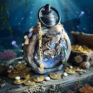 Peut inclure: Une bouteille décorative avec une poignée noire et une chaîne dorée, ornée de coquillages et d'une figure de sirène. Des pièces d'or et des perles sont dispersées sur une surface en bois, avec un coffre au trésor et un navire en arrière-plan. La scène se déroule sous l'eau.