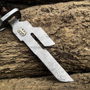 May include: A short sword with a patterned Damascus steel blade featuring a unique cutout design and a brass inlay near the hilt. The hilt has a metallic crossguard and a brown leather-wrapped handle, showcasing a distinct forged metal texture.