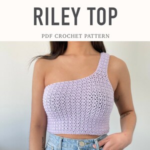 Pode incluir: Um top de crochê lilás claro, de um ombro só. O top é um estilo crop top com uma única alça sobre um ombro. O texto "RILEY TOP" é exibido acima do texto "PDF CROCHET PATTERN".