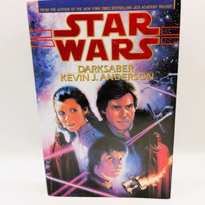 May include: A hardcover book titled "Star Wars: Darksaber" by Kevin J. Anderson. The cover features a space scene with character portraits and the Star Wars logo in red. The text "From the author of the New York Times bestselling Jedi Academy Trilogy" is at the top.
