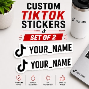 Op de afbeelding: Een set van twee aangepaste vinylstickers met het zwarte TikTok-logo en de tekst YOUR_NAME in een vetgedrukt schreefloos lettertype. De stickers worden getoond naast een witte beker en een laptop met hetzelfde ontwerp.