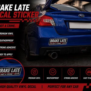 Op de afbeelding: Een rechthoekige autosticker met de witte tekst BRAKE LATE en de rood-witte tekst IT'S NOT A CRIME met een geblokte vlag-afbeelding. De sticker is aangebracht op de achterbumper van een blauwe auto met een spoiler en een uitlaatpijp.
