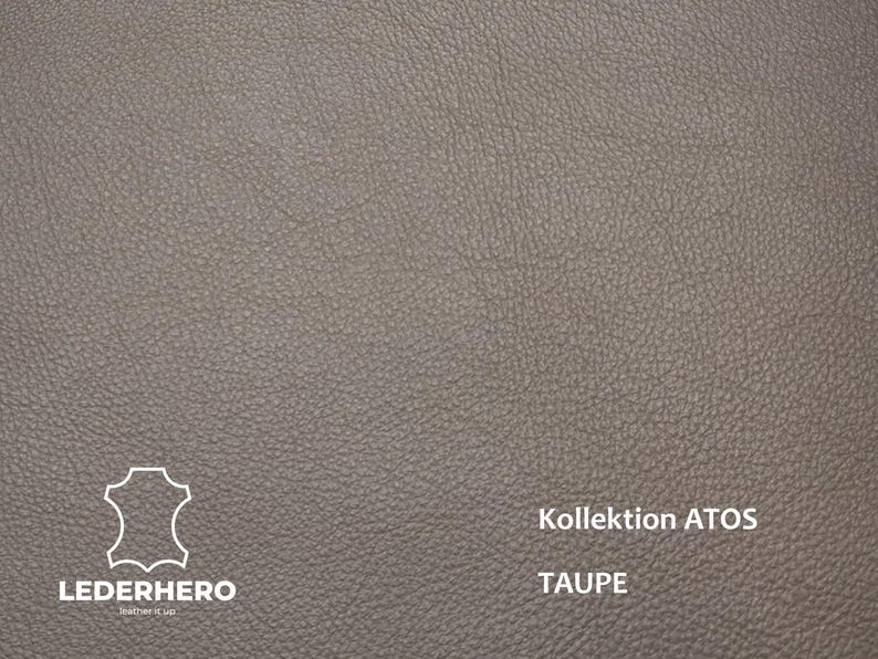 May include: Close-up of taupe-colored leather with a textured surface. The image includes the text "Kollektion ATOS" and "TAUPE". The "LEDERHERO" logo is also visible. This leather is suitable for various crafting projects.