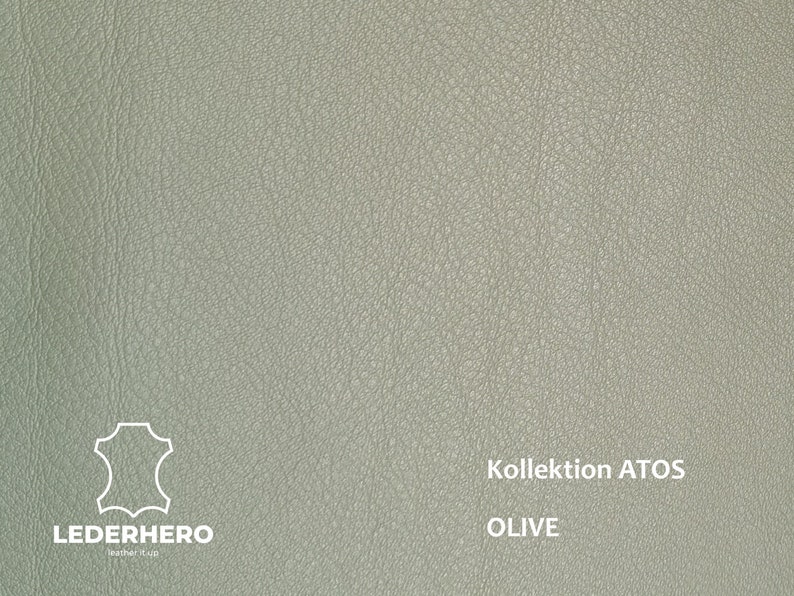 May include: A close-up of a light green leather swatch with the text "Kollektion ATOS OLIVE" printed on it. The leather has a textured surface.