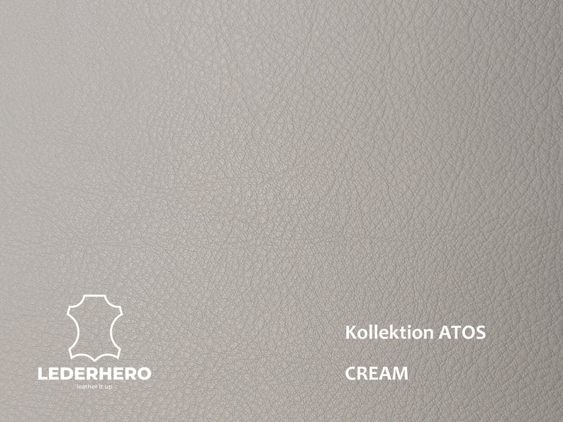 May include: Close-up of a light grey leather swatch with a textured surface. The swatch has the text "Kollektion ATOS CREAM" printed on it.