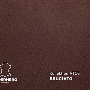 May include: Close-up of a textured, dark brown leather material. The image features the Lederhero logo and text that reads "Kollektion ATOS BRUCIATO". The leather has a subtle grain and a rich, warm color.