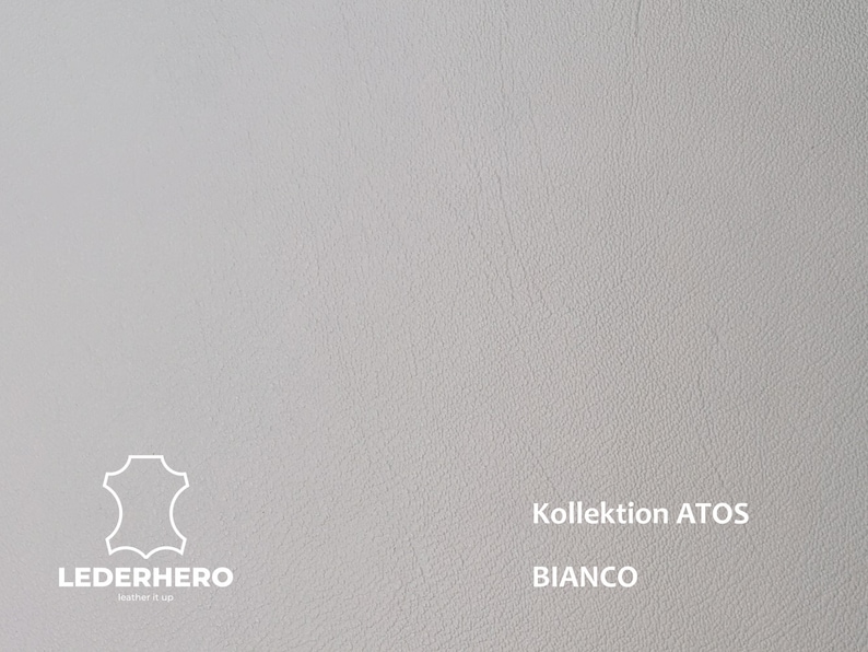 May include: A close-up of a white leather swatch with a textured surface. The text "Kollektion ATOS BIANCO" is printed in black at the bottom of the swatch.