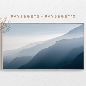 Könnte beinhalten: Ein gerahmter Druck einer nebeligen Berglandschaft in Blautönen. Der Druck ist von einem dünnen, hellbraunen Rahmen umgeben. Der Text "PAY3&GET5 PAY5&GET10" ist über dem Rahmen gedruckt.