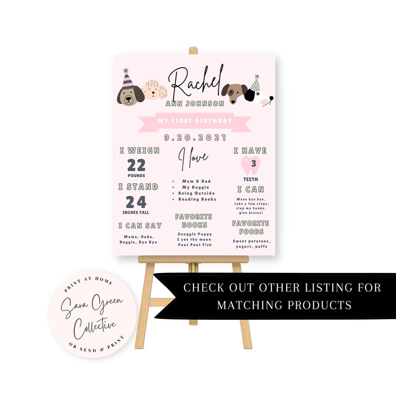 May include: A pink and white first birthday sign on an easel. The sign features the name "Rachel Ann Johnson" and details such as weight (22 pounds), height (24 inches), and favorite things. The sign includes dog illustrations and the text "Check out other listing for matching products."