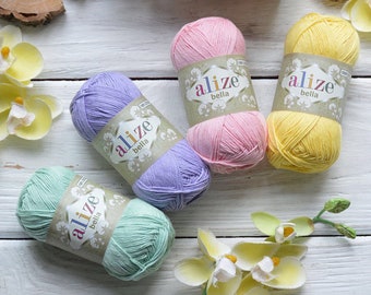 May include: Five balls of yarn in different pastel colors, including pink, yellow, green, purple, and light blue. Each ball has a label that says "alize bella" in white letters.