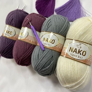 May include: Four balls of yarn in different colours: purple, burgundy, grey, and white. Each ball has a label that says "Nako Super Inci".