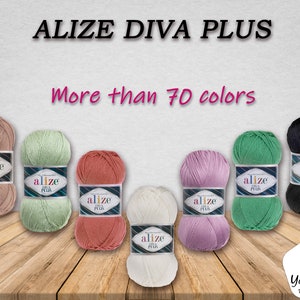 Pode incluir: Fio Alizé Diva Plus em uma variedade de cores, incluindo bege, verde, coral, lavanda, branco e preto. O fio é exibido em uma superfície de madeira com o texto "Mais de 70 cores" acima do fio.