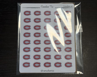 Op de afbeelding: Een wit stickervel met vijfenveertig kleine rode, witte en blauwe logo's van het ijshockeyteam Montreal Canadiens. Bovenaan het vel staat de tekst Canadian Tai en Canadiens xs, terwijl onderaan de tekst @canadiantai is weergegeven.