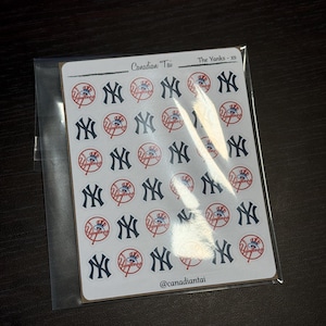 May include: A sheet of small adhesive stickers featuring the navy blue interlocking NY logo and a circular red and blue baseball-themed logo with the text Yankees. The sheet is labelled Canadian Tai, The Yanks - xs, and @canadiantai at the bottom.