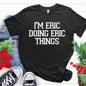 May include: Black t-shirt with white text that reads "I'm Eric Doing Eric Things".
