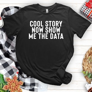Puede incluir: Camiseta negra con texto blanco que dice "Cool story now show me the data".