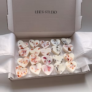 May include: A box of heart-shaped wax melts. The melts are white with floral and marbled accents. The box is white with the text "LINES STUDIO" on the lid.