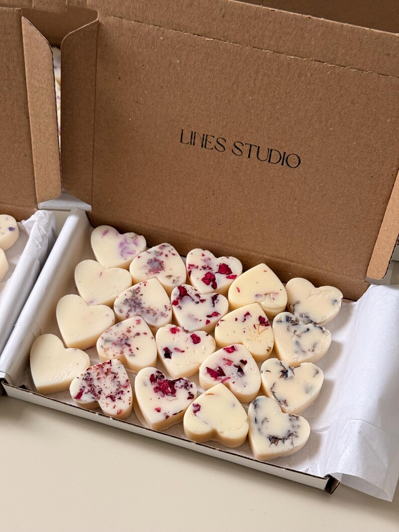 May include: A box of heart-shaped soaps. The soaps are white with floral accents in shades of red, purple, and black. The box is brown and has the text "LINES STUDIO" printed on it.