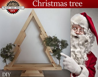 May include: A wooden Christmas tree frame with two small potted trees inside. The frame is made of natural wood and has a simple design. The tree is standing on a white surface. The text "Christmas tree" is written in red letters above the tree. A photo of Santa Claus is on the right side of the image. The text "DIY" is written in the bottom left corner of the image.