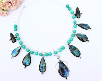 May include: A silver necklace featuring turquoise beads and teardrop-shaped labradorite stones. The necklace is a statement piece with a distinctive design.
