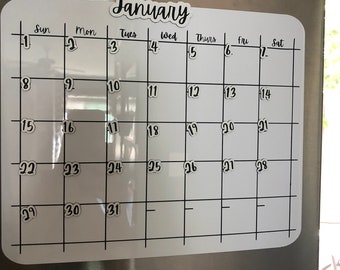 May include: A white magnetic monthly calendar board with rounded corners, featuring black grid lines and the word January at the top. The calendar displays the days of the week and numbers one through thirty-one in a black script font.
