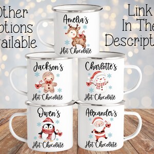 Puede incluir: Seis tazas de esmalte blanco con diferentes dise&ntilde;os navide&ntilde;os y nombres. Cada taza tiene un dise&ntilde;o rojo y blanco con un personaje diferente, incluyendo un reno, un hombre de jengibre, un mu&ntilde;eco de nieve, un ping&uuml;ino y Santa Claus. Las tazas est&aacute;n todas etiquetadas con el texto "Chocolate caliente".