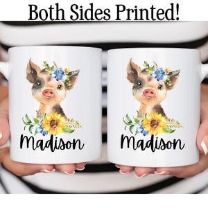 May include: Two white ceramic mugs with a watercolor illustration of a pig wearing a flower crown and the name "Madison" printed on each mug.