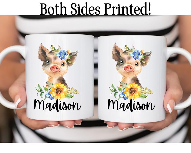 May include: Two white ceramic mugs with a watercolor illustration of a pig wearing a flower crown and the name "Madison" printed on each mug.