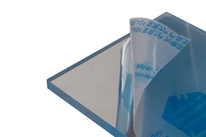 May include: A clear acrylic sheet with a protective film on one side. The film has blue text that reads "克宝2A", "主品克宝", "ZAJO", "SUARANTEE", "NO YELLOWING", "&Pi;&omicron;&tau;ί&nu;&eta;&sigmaf;", and "tutitanl".