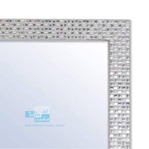 Può includere: Uno specchio argentato con una cornice testurizzata. La cornice ha un motivo di piccoli quadrati. Lo specchio ha il testo "Taller del cuadro" e "www.tallerdelcuadro.online" stampato su di esso.