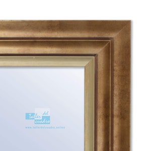 Könnte beinhalten: Ein goldener Bilderrahmen mit einem doppelschichtigen Rahmen. Der Rahmen hat einen hellgoldenen Innenrahmen und einen dunkleren goldenen Außenrahmen. Der Rahmen ist aus Holz und hat eine Antik-Optik. Der Rahmen ist leer und bereit, um ein Bild oder ein Kunstwerk zu präsentieren. Der Text "Taller del cuadro" und "www.tallerdelcuadro.online" ist in der linken unteren Ecke des Rahmens sichtbar.