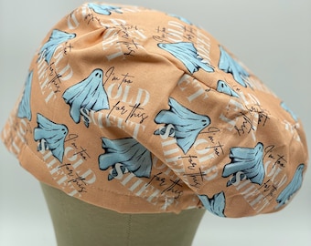 Puede incluir: Un gorro de quirófano de color melocotón con un patrón repetido de fantasmas azules y el texto "Soy demasiado viejo para esta sábana".