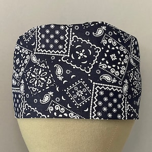 May include: A black scrub hat with a white bandana print. The hat is made of a soft, comfortable fabric and is perfect for keeping hair out of your face while you work.