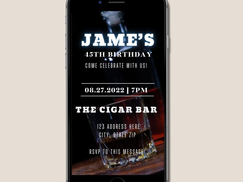 K&ouml;nnte beinhalten: Ein Smartphone-Bildschirm mit einer Geburtstagseinladung zum 45. Geburtstag von Jame. Die Einladung enth&auml;lt Datum und Uhrzeit der Party, den Ort und eine Bitte um RSVP. Das Hintergrundbild ist eine Nahaufnahme eines Glases Whisky.