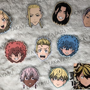 May include: Nine illustrated character stickers featuring different anime-style faces. The stickers are printed on white paper with a blue border. The characters have different hair colors and styles, including blonde, brown, red, and blue.
