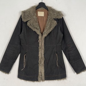 May include: A dark brown corduroy jacket with a faux fur collar and lining. The jacket has a zipper closure and two pockets on the front.